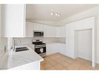 Bright kitchen with white cabinets, new countertops, and stainless steel appliances at 412 Vassar Ln, Las Vegas, NV 89107