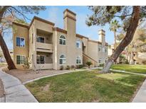 Exterior view of condo building with a lawn, stone landscaping, and stairs to the second floor at 3145 E Flamingo Rd # 1045, Las Vegas, NV 89121