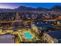 Night view of community pool, surrounding homes, and mountain backdrop at 600 N Carriage Hill Dr # 1164, Las Vegas, NV 89138