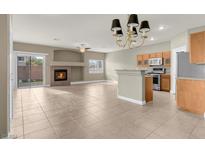 Open living room features a fireplace and tile flooring, adjacent to kitchen at 9165 Goose Lake Way # 103, Las Vegas, NV 89149