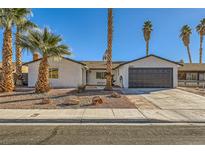 Remodeled single-story home with a landscaped front yard and new garage door at 3698 Rawhide Ct, Las Vegas, NV 89120