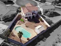 Aerial view of a fenced backyard, featuring a private pool with a desert landscape and a detached shed at 504 Landra Ln, Henderson, NV 89015