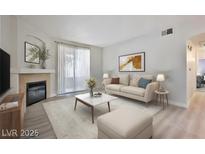 Bright living room features a comfy sofa, coffee table, and fireplace at 1830 N Buffalo Dr # 1091, Las Vegas, NV 89128