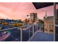 City view from balcony with sidewalks and street, and a colorful skyline with pink clouds at 353 E Bonneville Ave # 313, Las Vegas, NV 89101