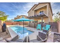 Inviting backyard pool with patio seating and modern two-story house backdrop at 6482 Twin Harbors Ct, Las Vegas, NV 89141