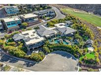 Stunning aerial view of luxury estate with lush landscaping, pool, and golf course in the background at 677 Boulder Summit Dr, Henderson, NV 89012