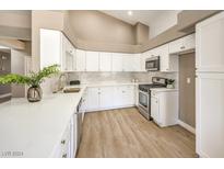 Modern kitchen with white cabinets, quartz countertops, and stainless steel appliances at 6316 W Gowan Rd, Las Vegas, NV 89108