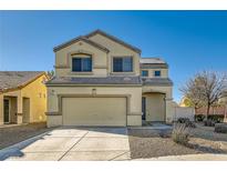 Two-story house with beige exterior, two-car garage, and landscaped yard at 6547 Velvet Silk St, North Las Vegas, NV 89084