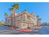 Tan two-story building with palm trees and attached garages at 7151 S Durango Dr # 214, Las Vegas, NV 89113