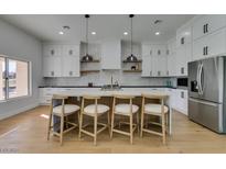 Modern kitchen with white cabinets, marble countertops, and island at 8713 Litchfield Ave, Las Vegas, NV 89134