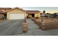 Single-story house with attached garage, solar panels, and landscaped walkway at 1550 Desertaire Way, Las Vegas, NV 89110