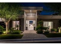 Modern home exterior at night, featuring a sleek design and well-manicured landscaping at 667 Palisade Rim Dr, Henderson, NV 89012