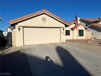 Single story home with a stucco exterior, two car garage, and a red tile roof, accented by an American flag at 4764 Anchorage St, Las Vegas, NV 89147