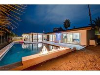 Inviting backyard with a sparkling pool and fire pit at 2240 Mohigan Way, Las Vegas, NV 89169