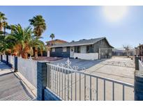 Ranch style home with gated front yard and palm trees at 2817 Mardi Gras Ln, North Las Vegas, NV 89030