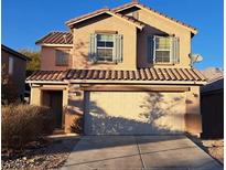 Two-story house with attached garage and desert landscaping at 5332 Iron Crossing Ave, Las Vegas, NV 89131