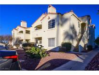 Spanish style condo building with a walkway and landscaping at 698 S Racetrack Rd # 214, Henderson, NV 89015