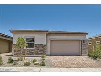 Charming single-story home with stone accents, manicured landscaping, and a brick driveway at 106 Barkset Way, Henderson, NV 89011