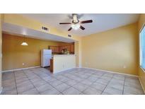 Spacious living room featuring tile flooring, a ceiling fan, and a pass-through to the kitchen at 2020 Rancho Lake Drive Dr # 205, Las Vegas, NV 89108