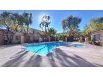 Inviting community pool and hot tub area surrounded by lush landscaping and wrought iron fencing at 2020 Rancho Lake Drive Dr # 205, Las Vegas, NV 89108