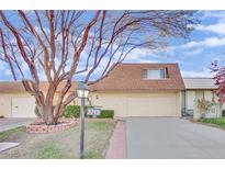 Tan colored exterior, attached garage, and manicured landscaping at 3719 Colonial Dr, Las Vegas, NV 89121