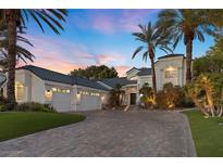 Elegant home boasts lush landscaping, a three-car garage, and a welcoming front entrance at sunset at 2337 Prometheus Ct, Henderson, NV 89074