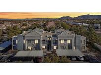 Two-story condo with a gray exterior, covered parking, and mountain views at 2201 Ramsgate Dr # 327, Henderson, NV 89074