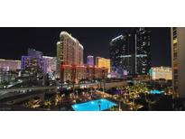 Bright pool area with palm trees and views of the Las Vegas strip at night at 135 E Harmon Ave # 407, Las Vegas, NV 89109