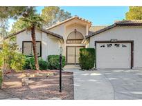 Single-story home with attached two-car garage and landscaped front yard at 5421 Broadwater Ln, Las Vegas, NV 89130