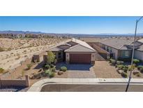 Charming single-story home featuring desert landscaping, a brick-paved driveway, and a two-car garage at 2039 Port Royal Dr, Laughlin, NV 89029