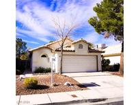 Single-story house with a two-car garage and landscaped front yard at 5467 Morning Swim Ln, Las Vegas, NV 89113