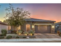 Single-story home with landscaped yard, two-car garage, and brick driveway at 5433 Strawberry Swing St, North Las Vegas, NV 89081