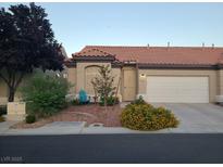 Charming single-story home with a well-maintained yard and desert landscaping, including mature trees and flowering bushes at 5048 Orchid Springs St, Las Vegas, NV 89148