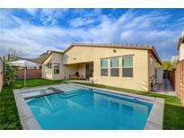 Inviting backyard oasis with a sparkling pool, patio furniture, and lush landscaping at 1705 Dream Canyon Ave, North Las Vegas, NV 89084