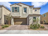 Two-story house with a brown garage door and landscaping at 1934 Karner Blue Ave, North Las Vegas, NV 89031