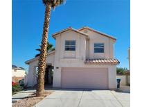 Two-story house with a pink garage door and a palm tree in the front yard at 5402 Night Swim Ln, Las Vegas, NV 89113