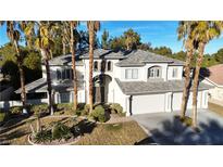 Two-story house with gray roof, three-car garage, and palm trees at 10008 Rolling Glen Ct, Las Vegas, NV 89117