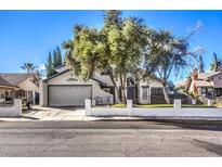 Single-story house with a gray garage door and a well-maintained lawn at 4705 Rockvale Dr, Las Vegas, NV 89103