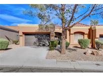 Tan one-story house with a brown door and two-car garage at 9452 Gold Mountain Dr, Las Vegas, NV 89134