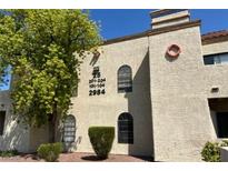 Spanish style building exterior with landscaping and a red curb at 2984 Juniper Hills Blvd # 102, Las Vegas, NV 89142