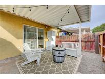 Charming covered patio area with stylish seating, outdoor rug, and convenient washer/dryer setup at 155 E Van Wagenen St, Henderson, NV 89015