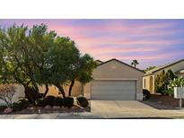 Single-story house with gray garage door and landscaping at 2185 Indigo Creek Ave, Henderson, NV 89012