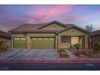 Green house with two-car garage, landscaping, and walkway at 4062 Narada Falls Ave, North Las Vegas, NV 89085