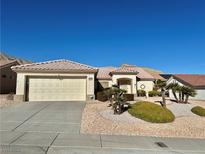 Single-story house with beige exterior, two-car garage, and desert landscaping at 2905 Faiss Dr, Las Vegas, NV 89134