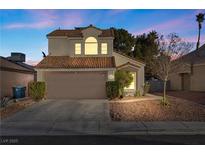 Two-story house with attached garage and landscaped yard at 7044 Morales Cir, Las Vegas, NV 89119