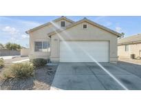 Single-story house with a white garage door and desert landscaping at 2005 Ona Marie Ave, North Las Vegas, NV 89032