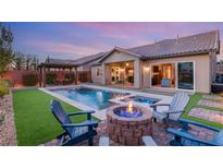 Stunning backyard with a sparkling pool, fire pit, and seating area at 7563 Saguaro Cactus Ave, Las Vegas, NV 89178