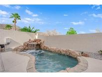 Relaxing backyard oasis with a spa and waterfall feature at 10646 Shifting Breeze Ave, Las Vegas, NV 89129