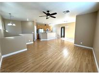 Bright living room with laminate wood floors and a view into the kitchen at 1350 Crystal Hill Ln # 3, Henderson, NV 89012