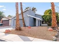 Gray house with palm trees and a landscaped yard at 4775 Summerhill Rd, Las Vegas, NV 89121